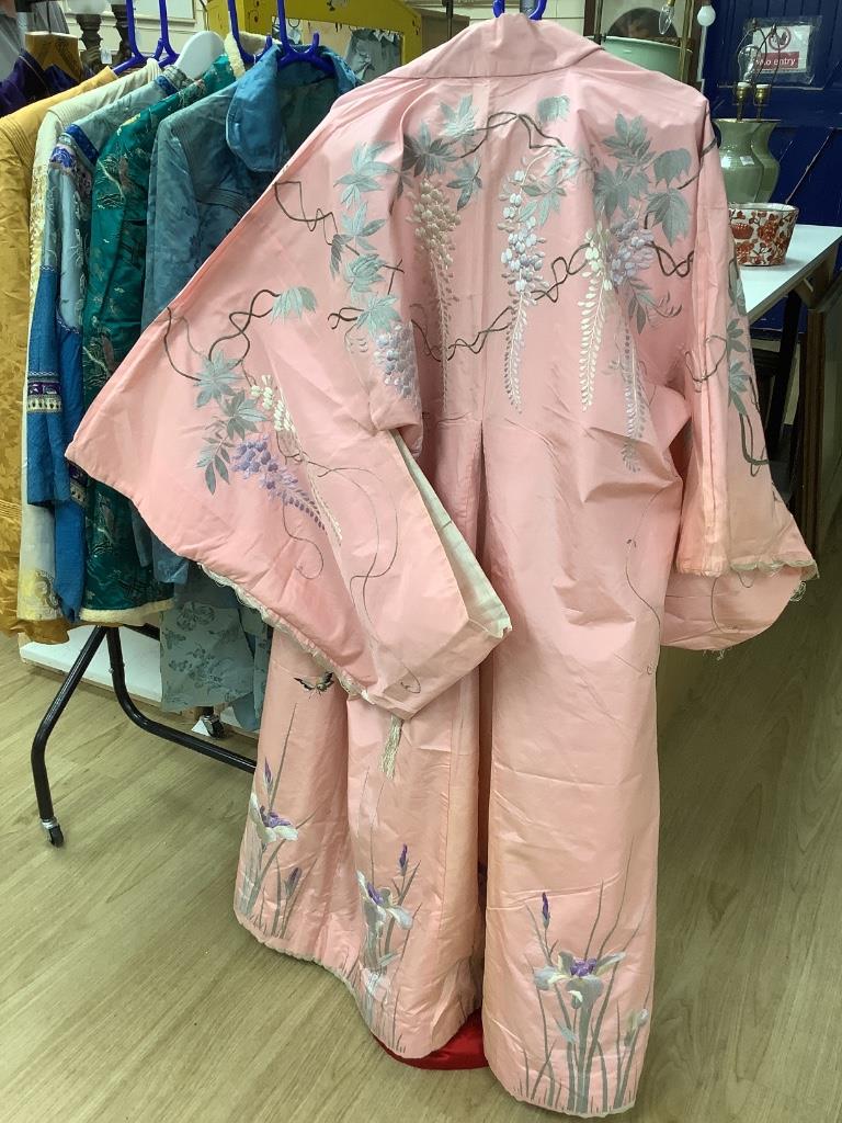 A pink silk Japanese kimono embroidered with wisteria and irises and butterflies, length 140cm, together with a red kimono embroidered with white wisteria and carnations